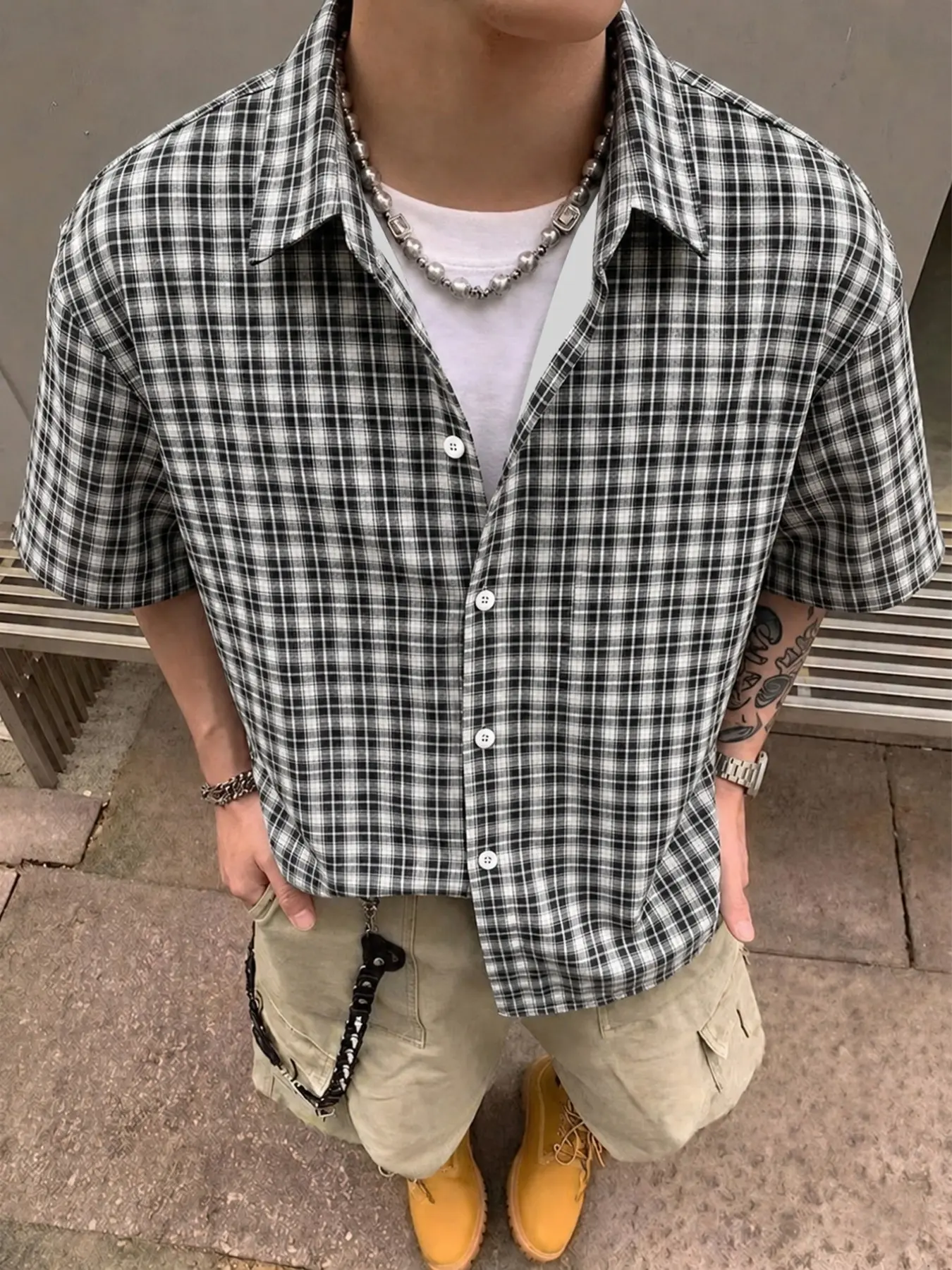 Men's short-sleeved Casual Collared Shirt featuring a black-and-white check plaid print—ideal for casual summer wear, street style, and city outings. A versatile top with a comfortable, classic check pattern.