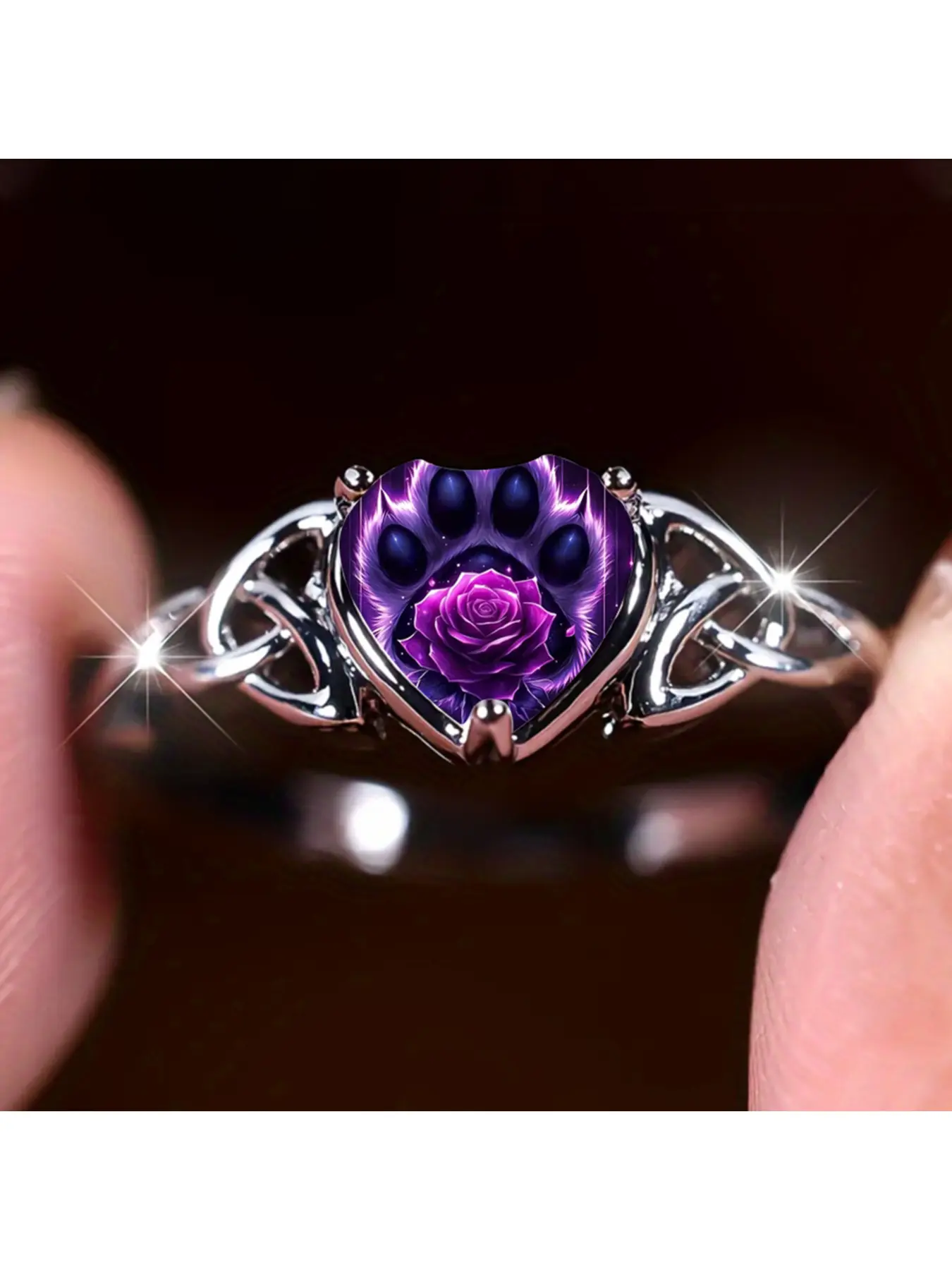 Purple Rose Cat Claw Heart Celtic Ring. On both sides of the ring body, classic interwoven Celtic knots are hollowed out. The heart-shaped main stone presents the outline of a fluffy cat paw in a dreamy purple tone. A deep purple rose is blooming in the c