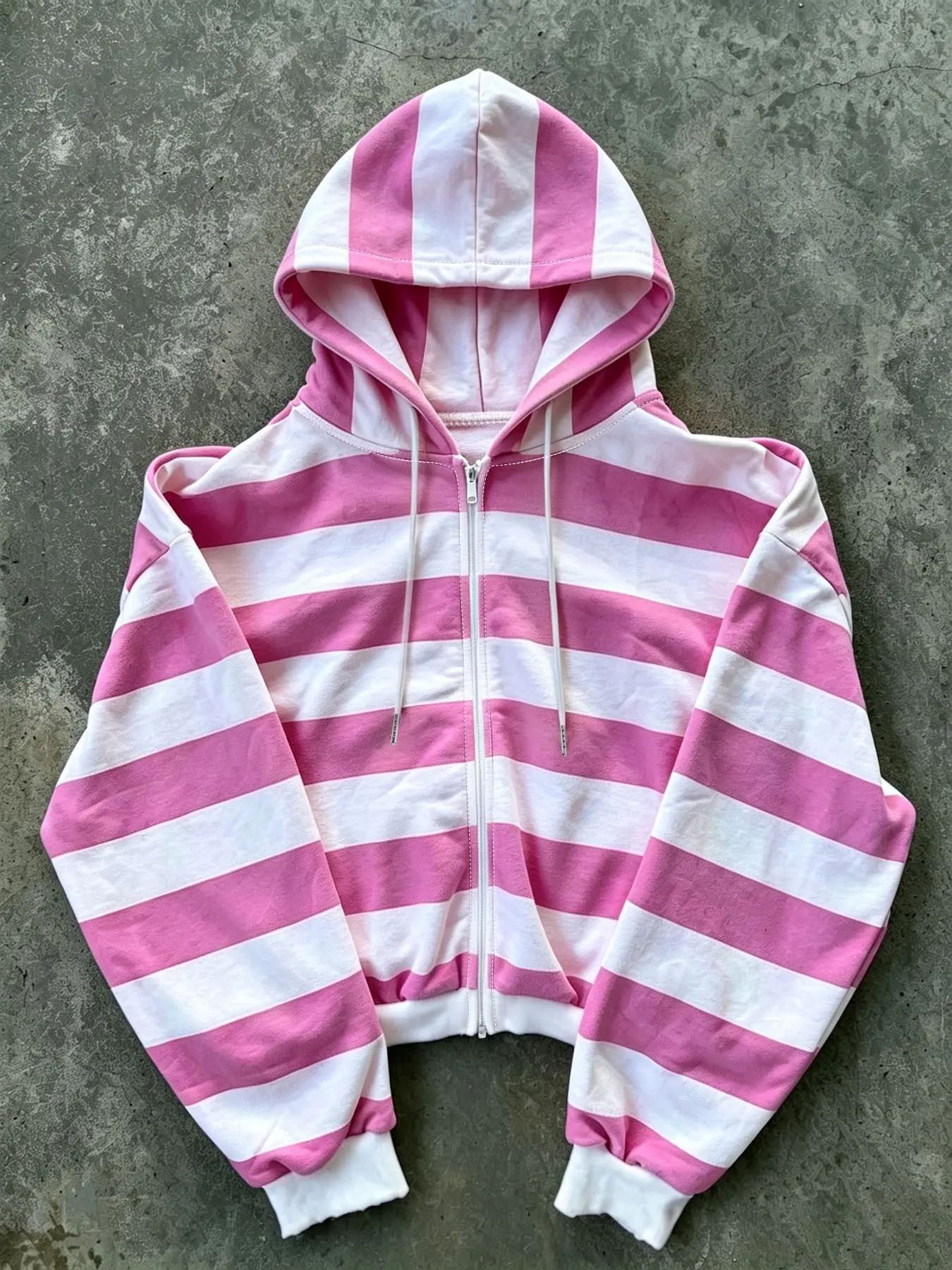 Women's pink and white striped cropped zip-up hoodie; a casual, long-sleeved, drawstring hooded sweatshirt suitable for everyday wear. Tops