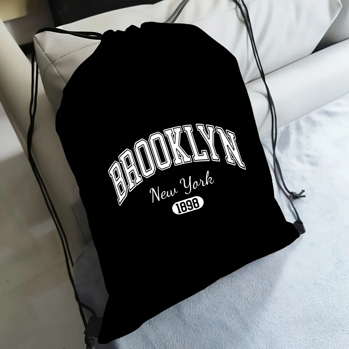 Stylish Black Drawstring Backpack with Ample Space, Designed in Brooklyn, New York in 1898, Featuring Adjustable Shoulder Straps, Perfect for Travel or Fitness Activities