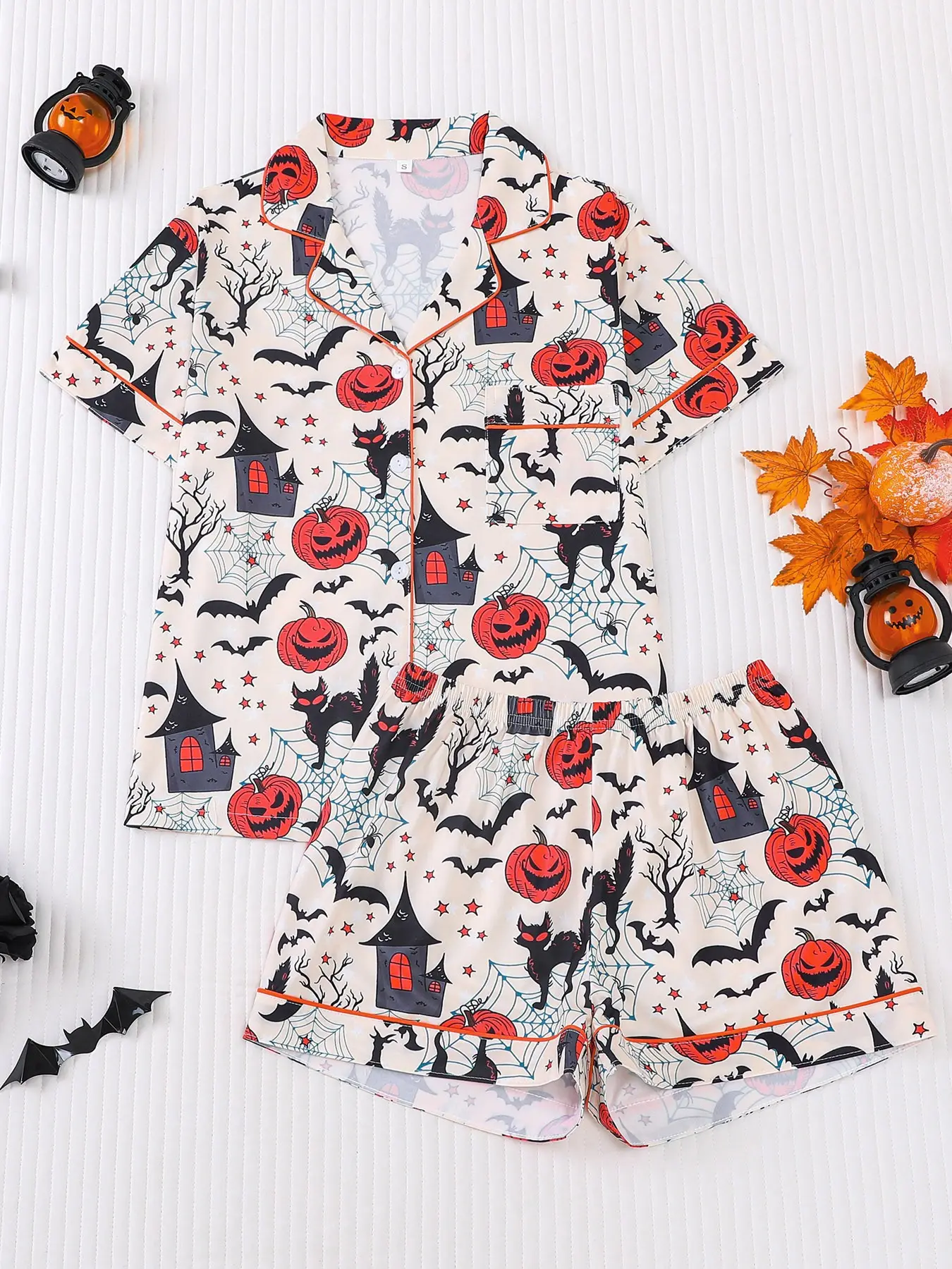 Women's 2-piece Halloween pajama set, Matching loungewear, off-white base with pumpkin, haunted house, black cat, bat, spider web print, retro style, orange-red piping trim. Lapel top with pocket, soft elastic shorts, all-season women casual loungewear