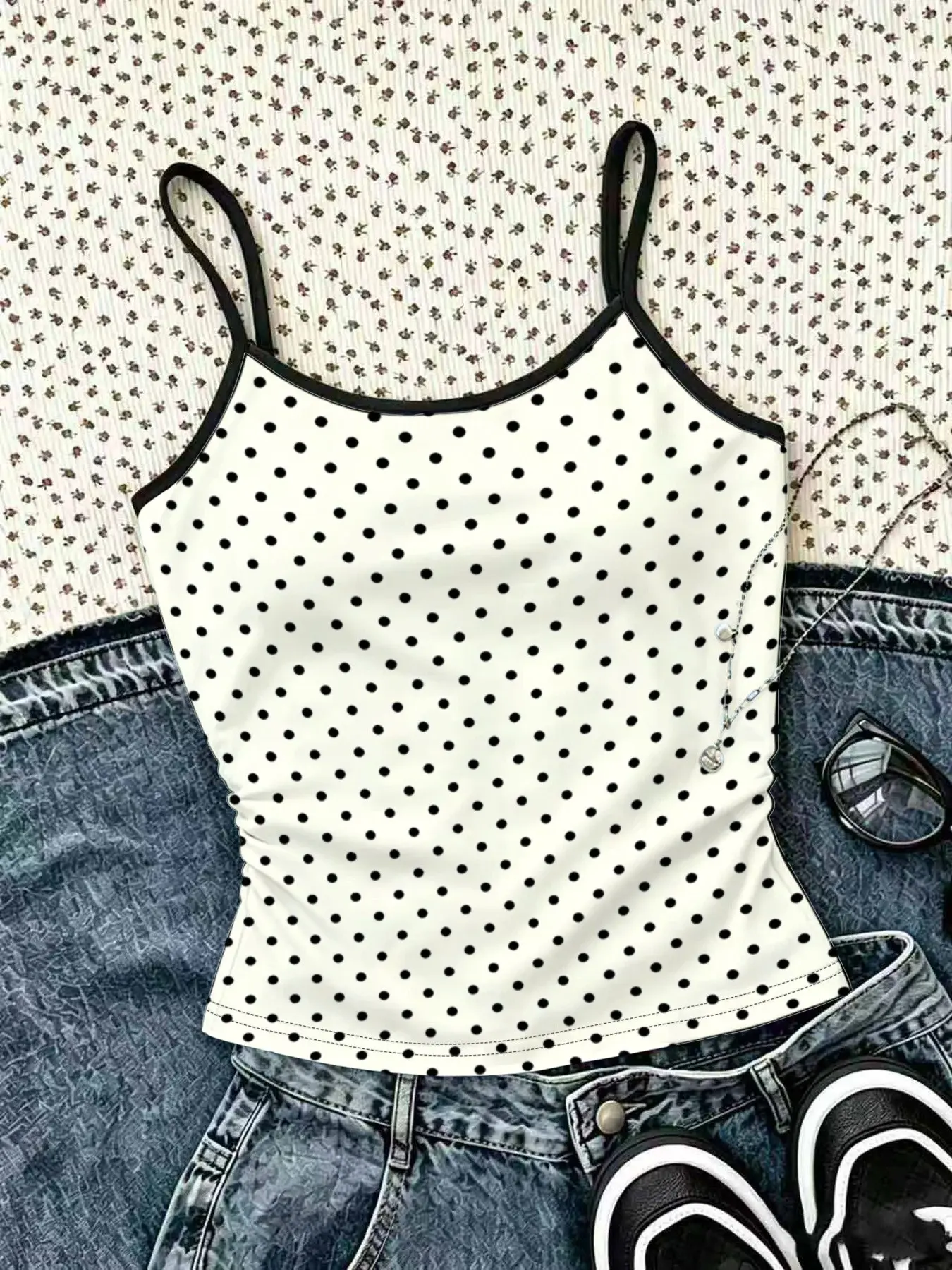 1-piece girls' tank top with classic black polka dot print and sleeveless thin shoulder strap design. The fabric is soft and breathable, suitable for summer children's casual wear and daily wear