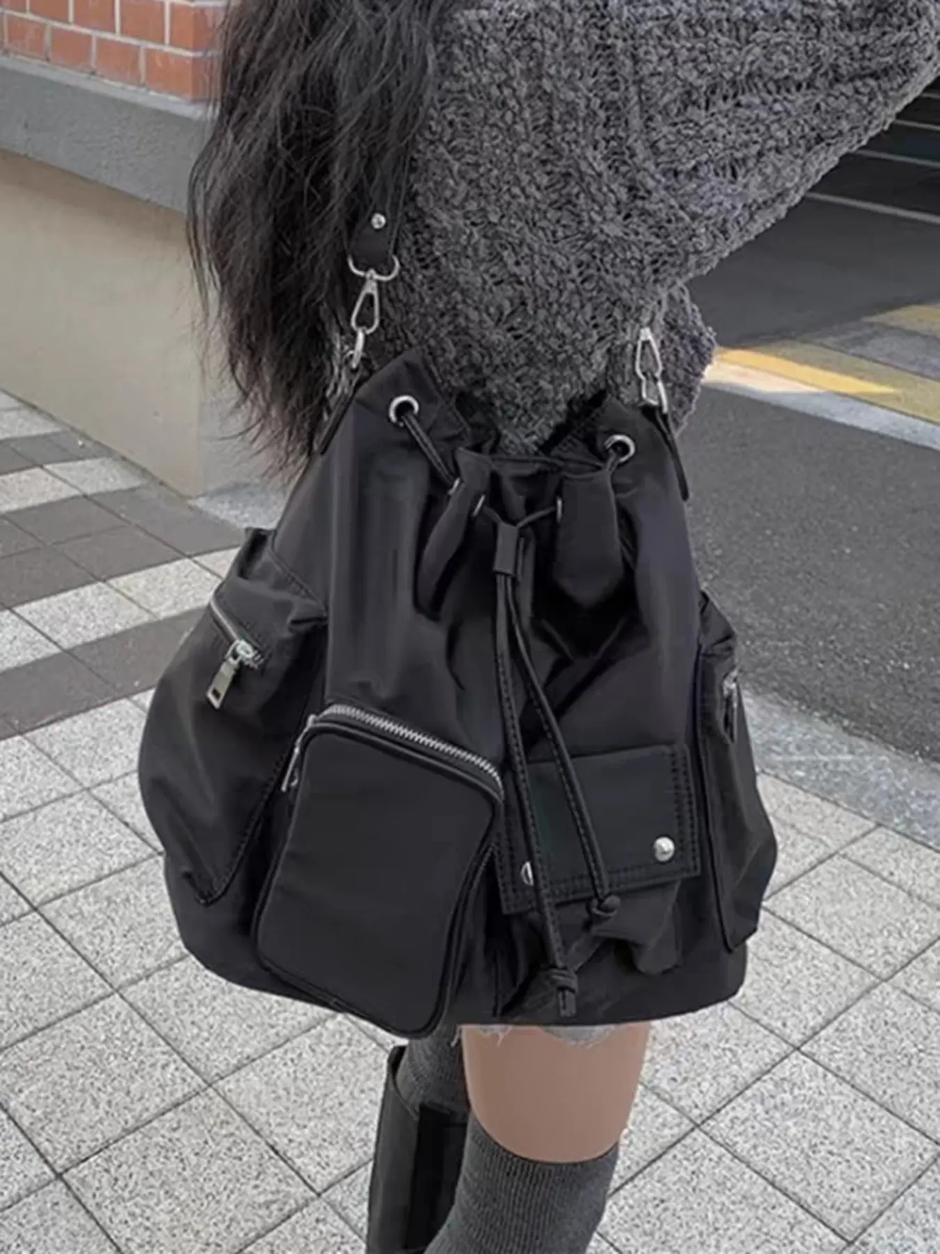 Minimalist black drawstring multifunctional backpack, lightweight and foldable for storage, multiple external pockets for organized storage, large capacity for commuting, traveling, gym, or shopping, a light and versatile backpack.