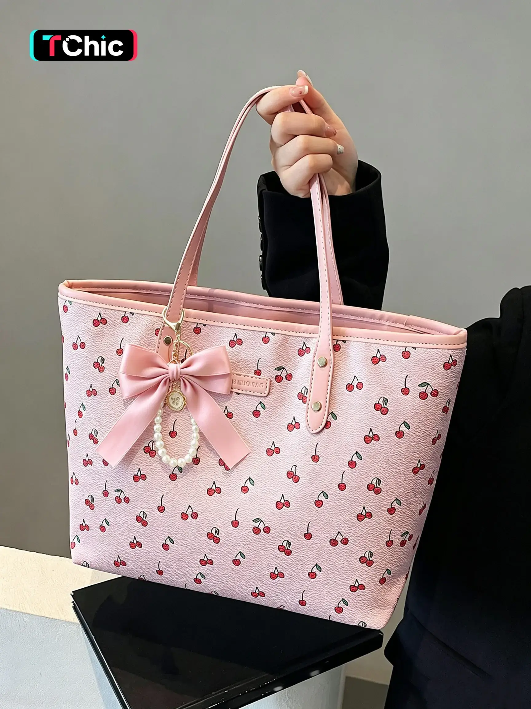 Niche design printed tote bag, paired with a delicate heart-shaped bow charm, a stylish and versatile large-capacity tote bag that's perfect for everyday commuting, shopping, or short trips—lightweight and practical.