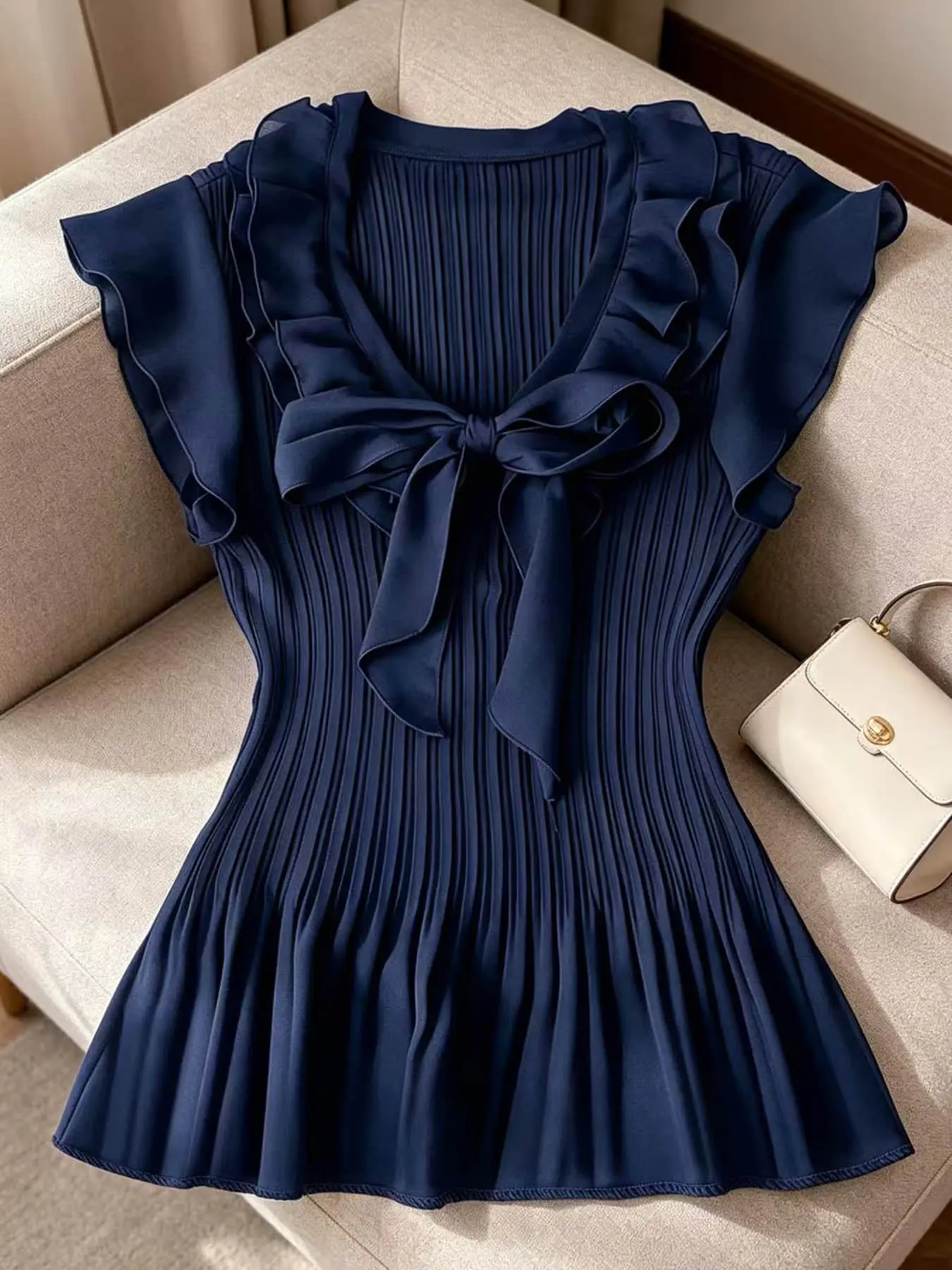 A women's fashionable and gentle style solid color pleated top with a cinched waist, bow, ruffle edge, and flying sleeves, suitable for summer, art exhibitions, afternoon tea, shopping, commuting, and travel.