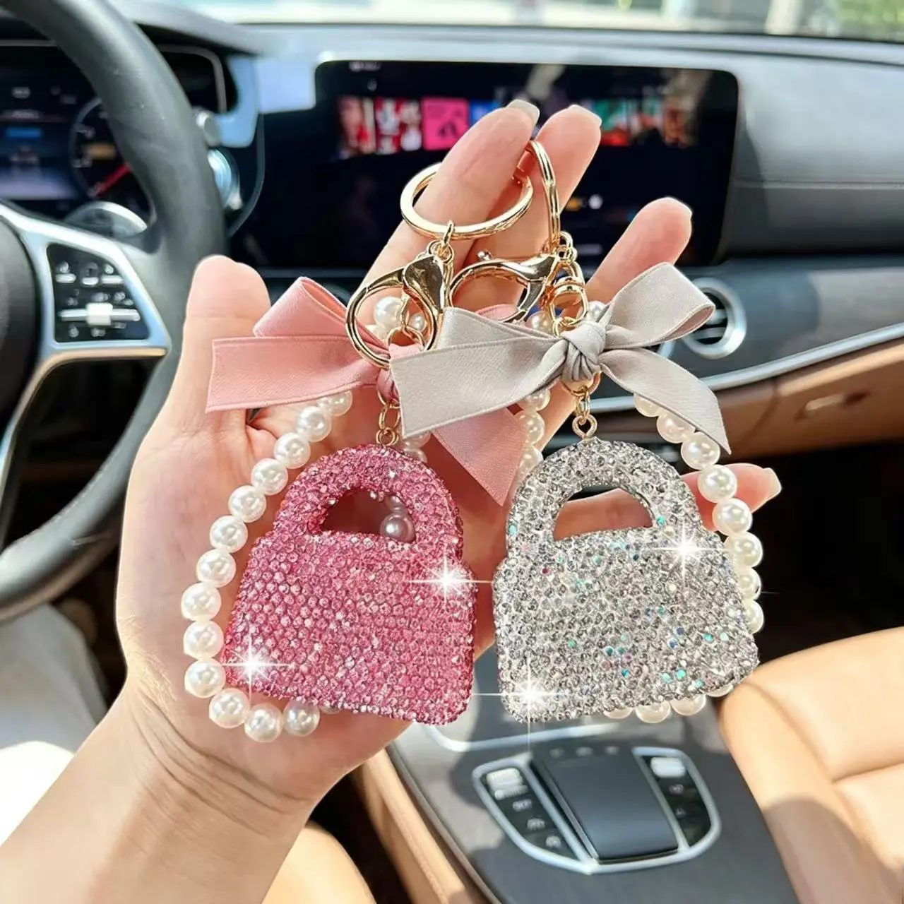 A stylish, sparkling rhinestone handbag-shaped keychain featuring a delicate mini-bag charm adorned with crystals, pearls, and a bow; suitable for use as a car keychain or backpack accessory. tote