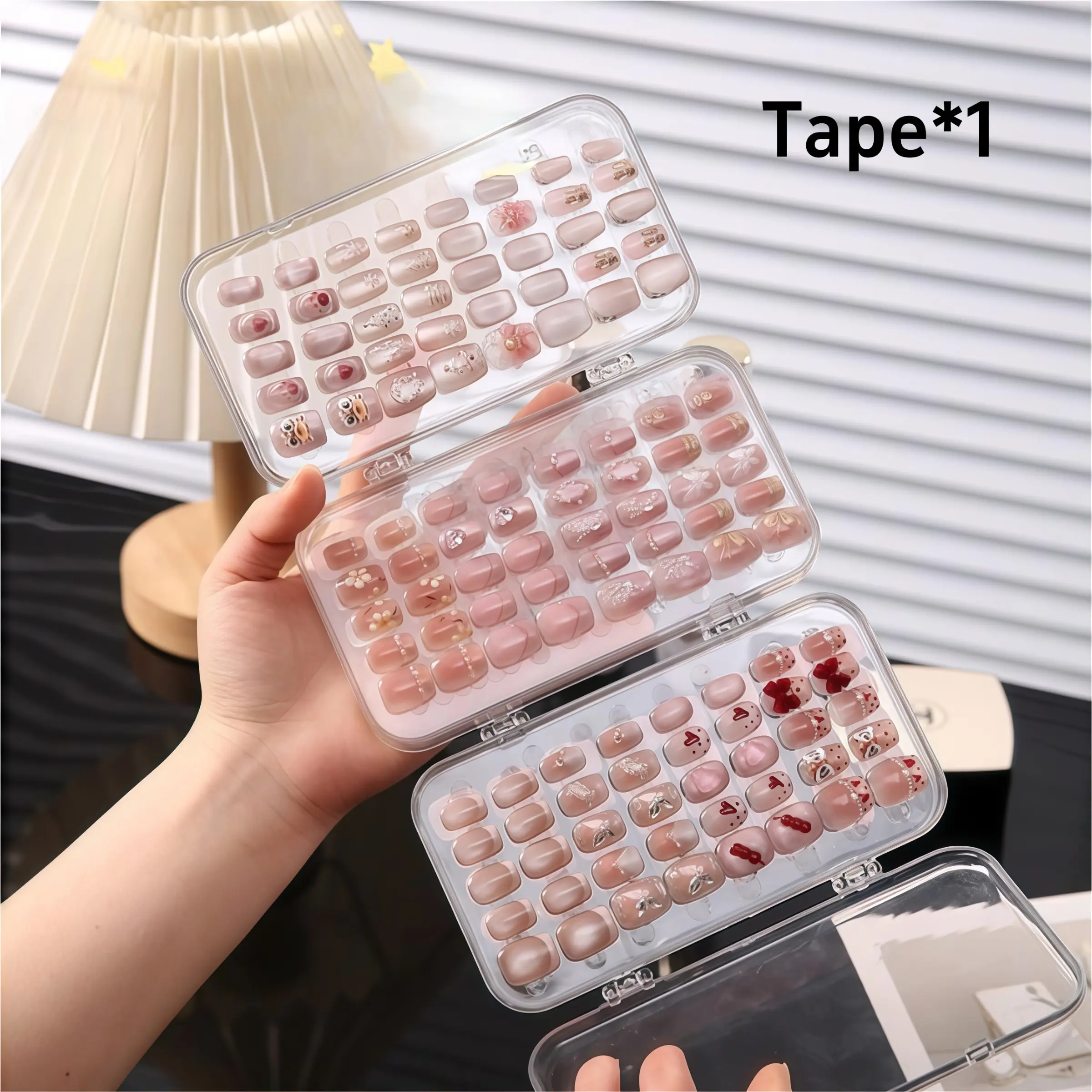 Portable tri-fold press-on nail storage box; transparent plastic organizer for display and storage; three-tier foldable case with compartments—ideal for press-on nails and nail art accessories.