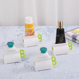 A set of 4 toothpaste tube rollers - manual squeeze tool, toothbrush squeezer, clip holder/winder, colors random.