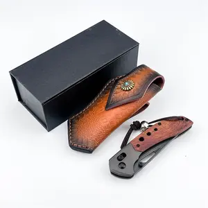 Retro Western-style folding knife, with aluminum + natural red sandalwood handle and skull pendant. Quick-opening hole design with D2 black blade. Hand-pressed floral leather sheath. Suitable for daily cutting, light outdoor use and knife collection.