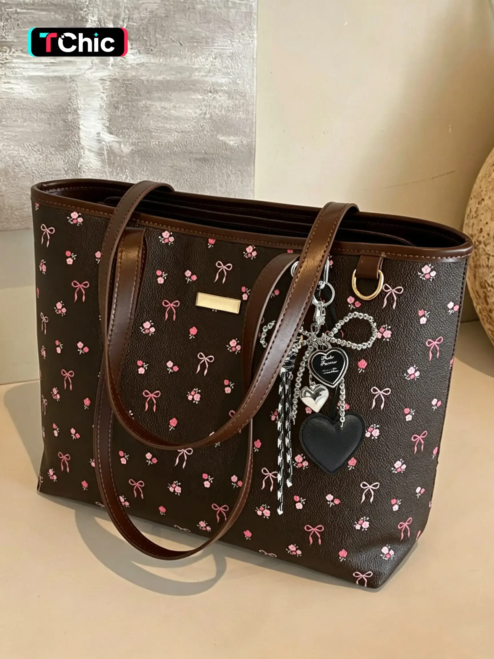 A gentle and fresh floral print leather tote bag, paired with a delicate detachable cute charm. Its large-capacity design makes it practical and versatile for everyday use, campus commuting, shopping, and short trips.