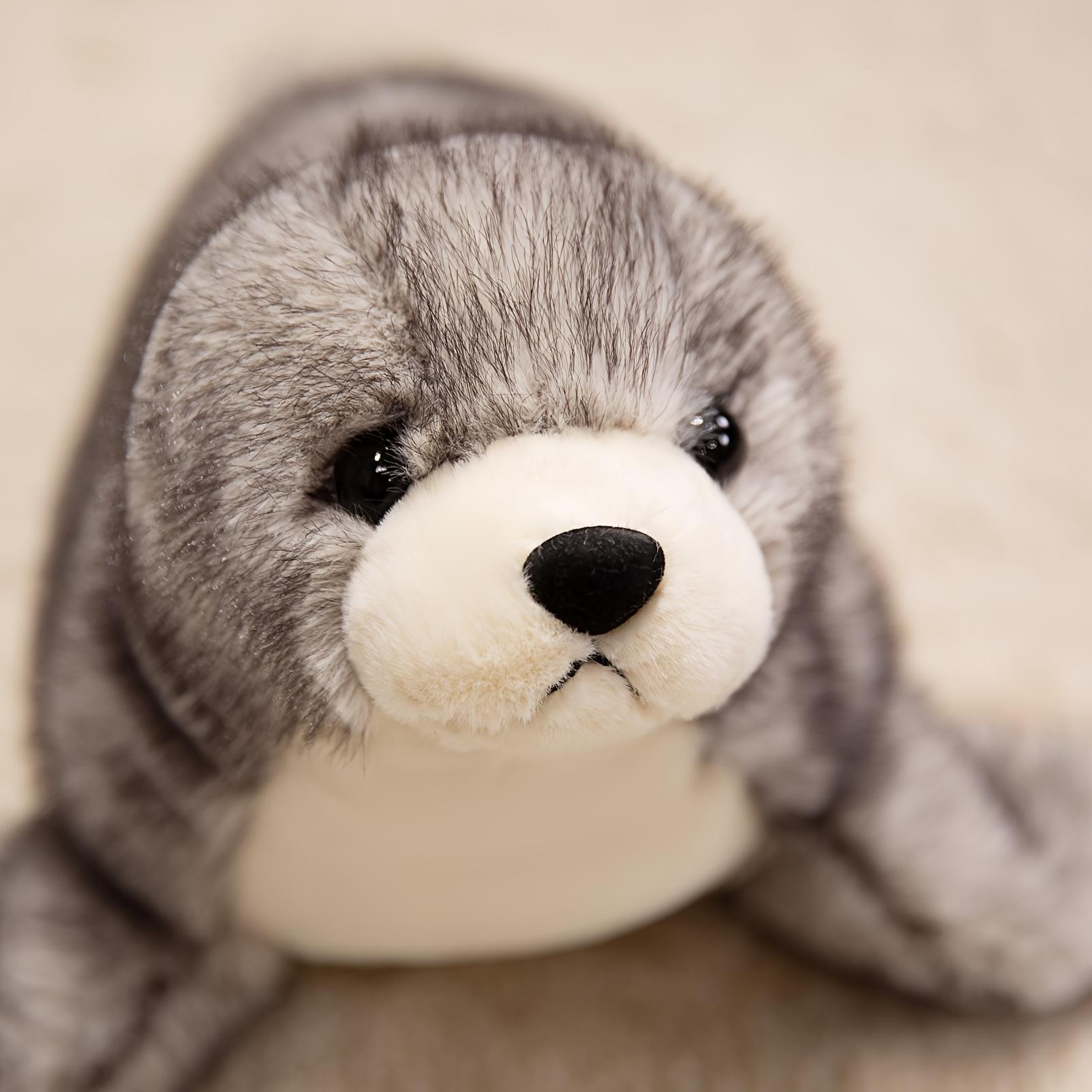 Adorable plush sea lion toy, super soft stuffed animal in a lazy pose, with silky fins suitable for cuddling and sensory play in the nursery
