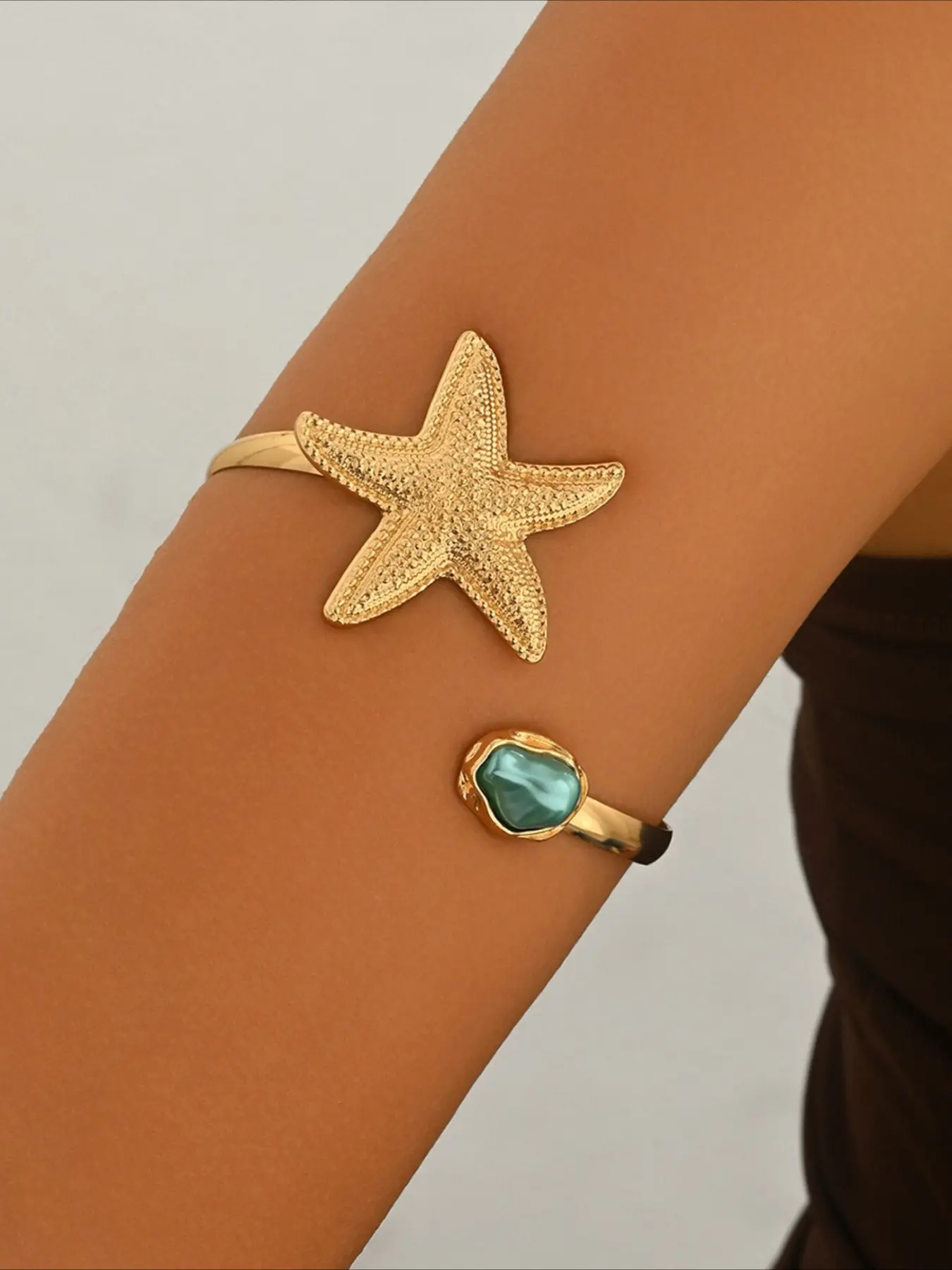 The upper arm of the fashionable armband is inlaid with acrylic starfish open bracelet, a simple metal armband
