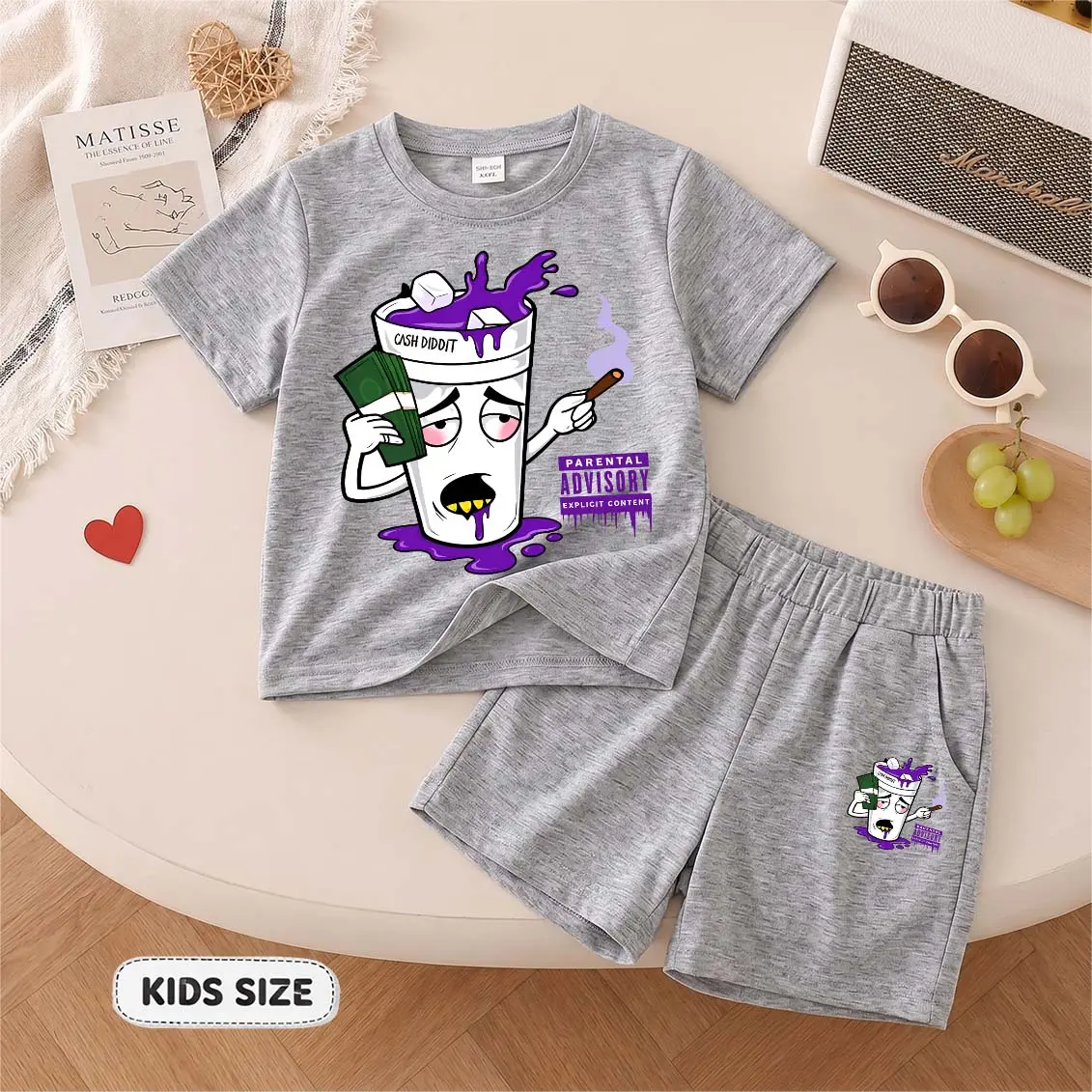 Kids’ “Purple Drink And Us Dollars” Cartoon Print Short-Sleeve T-Shirt And Shorts Set—Casual Summer Kids' Clothing. This Round-Neck Outfit Combination Is Perfect For Everyday Wear And Outdoor Play.