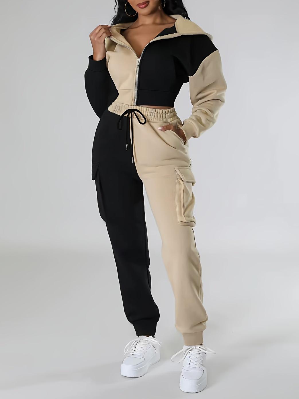 Sporty women's outfit: fashionable two-piece set with a short hooded jacket in contrasting colors and cargo sweatpants