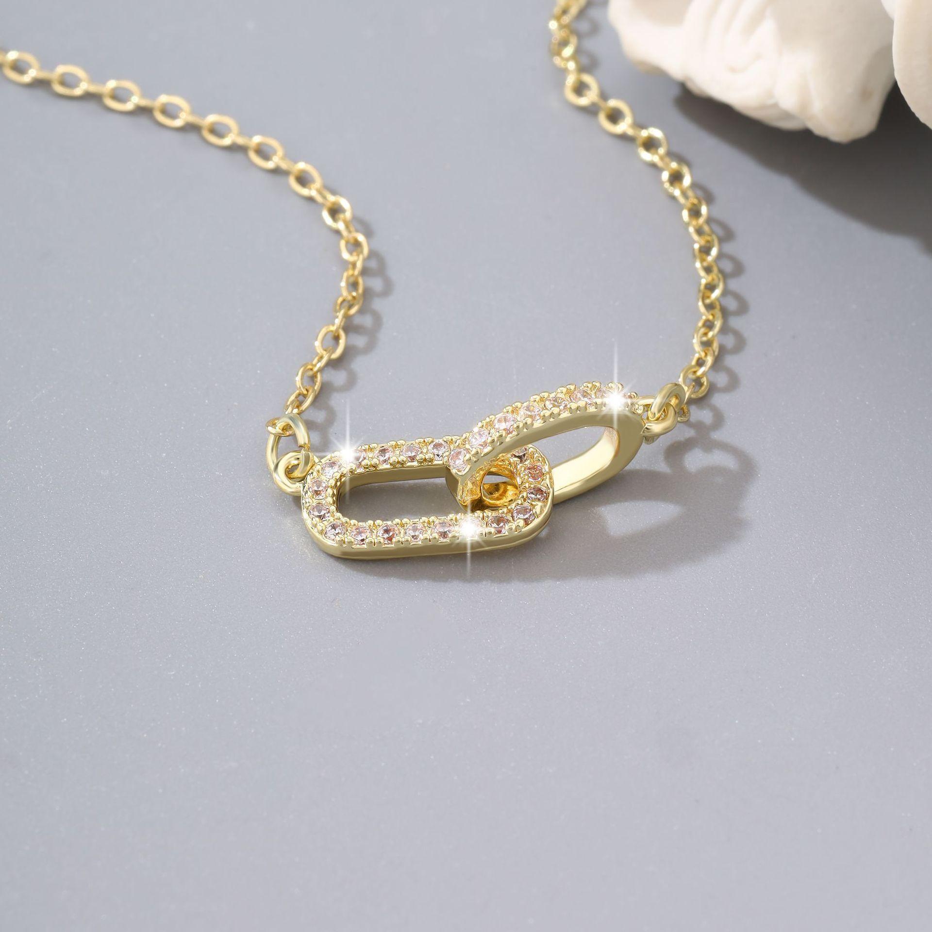 Oval necklace with interlocking double rings and diamond-encrusted pendant