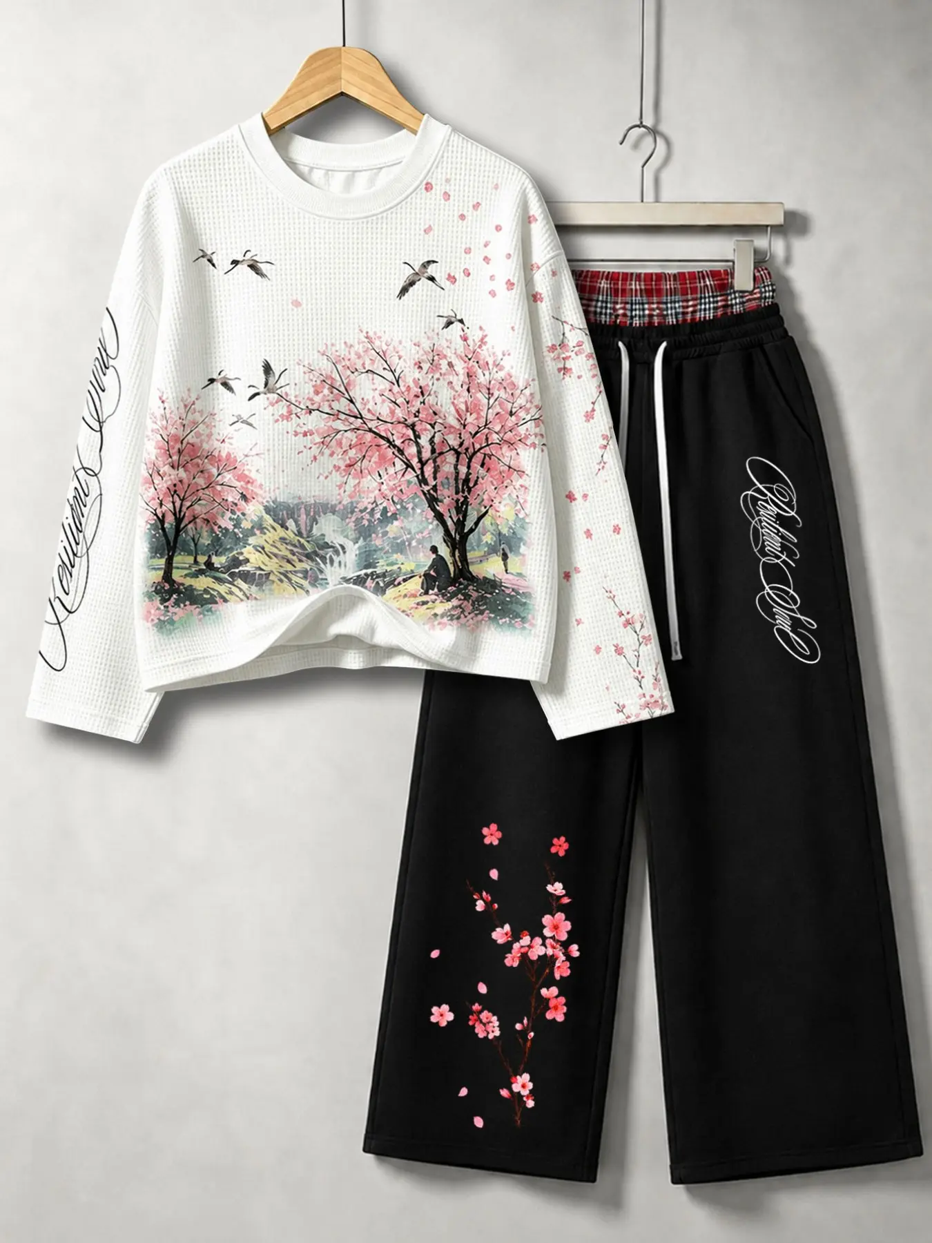 Men's waffle knit two-piece set: a cherry blossom landscape print crew neck long-sleeved sweatshirt and floral letter print wide-leg drawstring pants for a casual street style.
