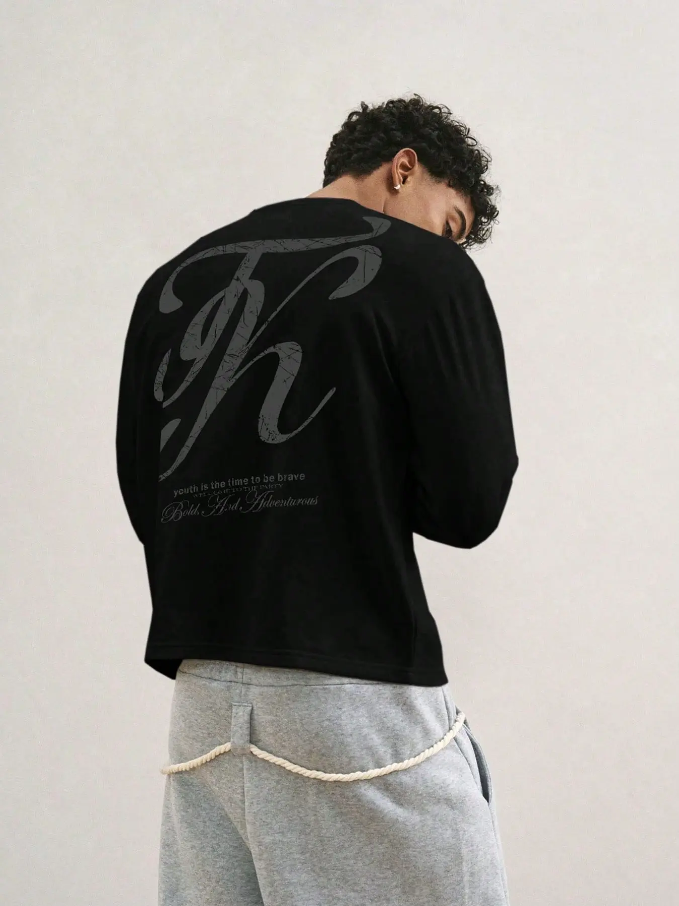 Y2K Black Cropped Crew Neck Long-Sleeve T-Shirt, pullover top with large cracked vintage faded script letter K print on the back, lightweight street base layer printed with small slogan phrases. Skin-friendly and breathable, it accentuates the waistline f