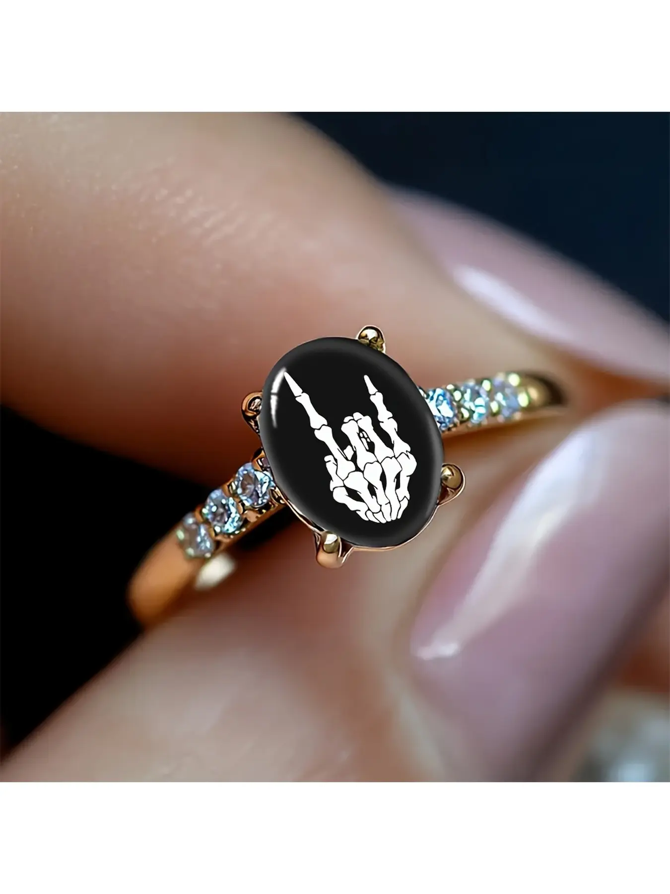 Pink flower sugar skull colored diamond gold ring, with a retro Mexican Day of the Dead style. The white skull is adorned with gilded patterns. Surrounding it are soft pink flowers, gently balancing the dark tone. On one side of the ring, there is a singl