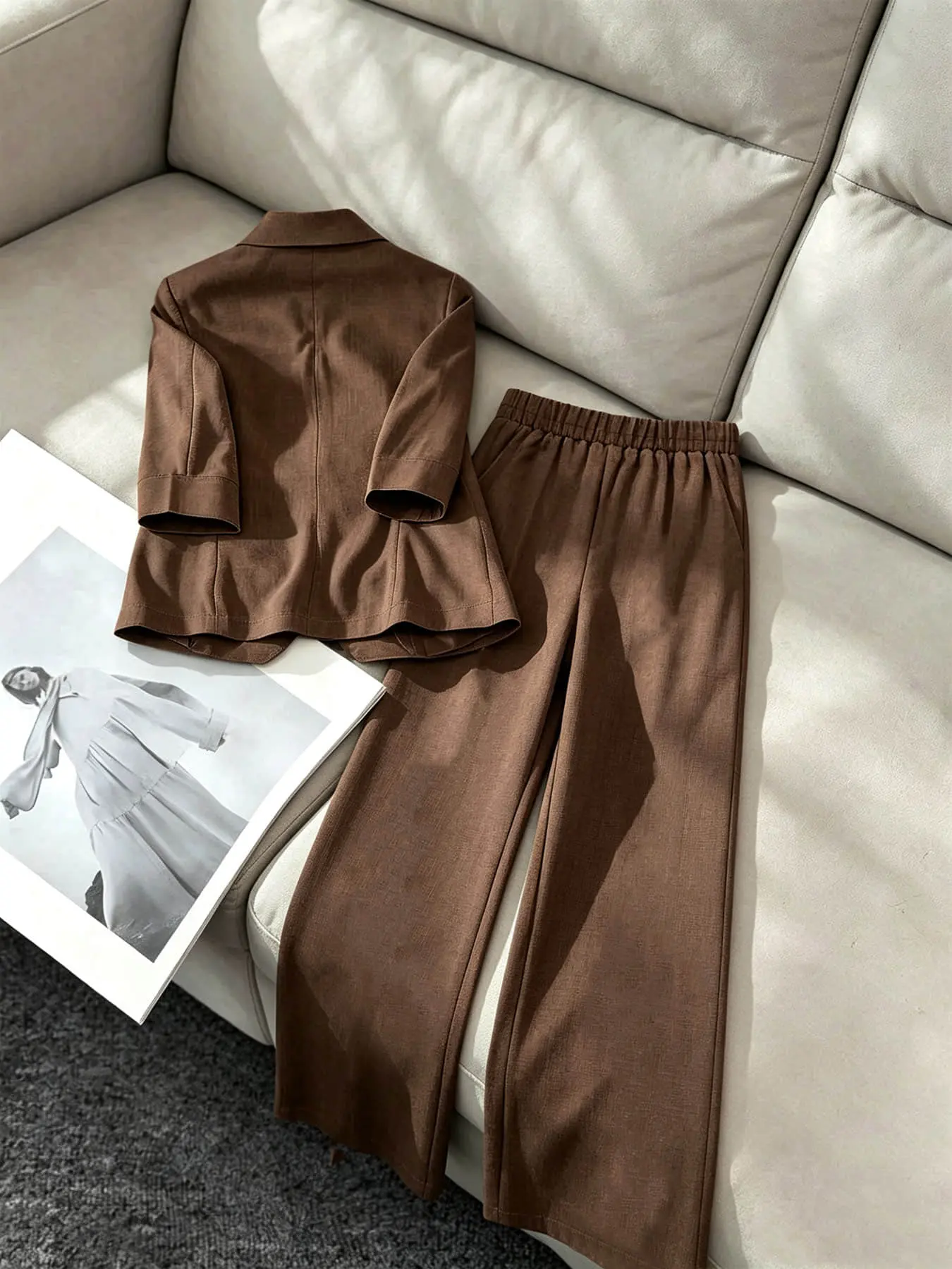 Two-piece women's fashion set in brown, featuring a lapel, single row of buttons, curved pockets, a mid-length sleeve blazer, and high-waisted wide-leg pants. Suitable for all seasons and ideal for both business occasions and casual street wear