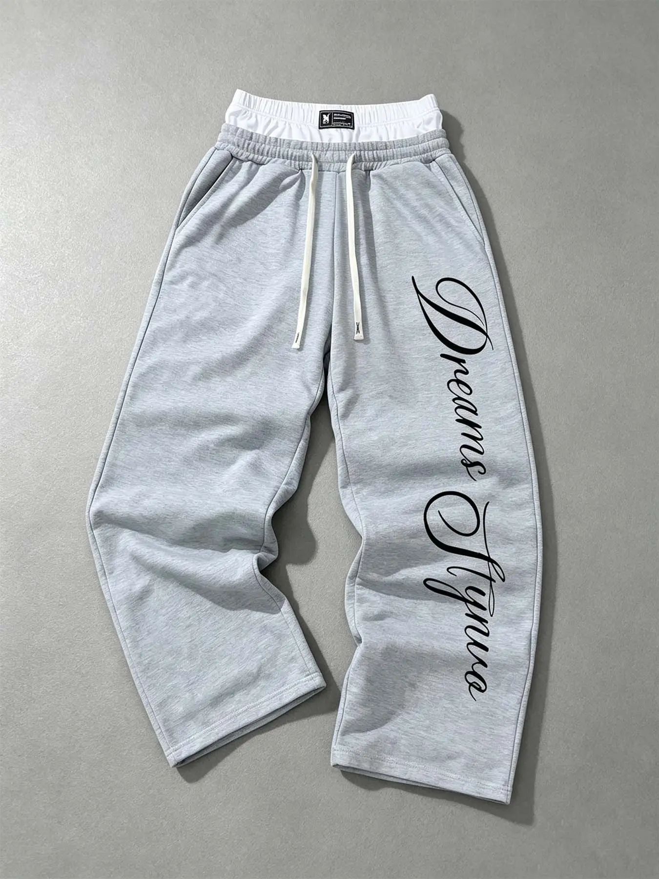 Gray double-waistband wide-leg sweatpants with cursive letter prints, layered waistband design, loose street-style pants, made of soft and comfortable fabric. Suitable for campus gatherings, workouts, and weekend casual outings.
