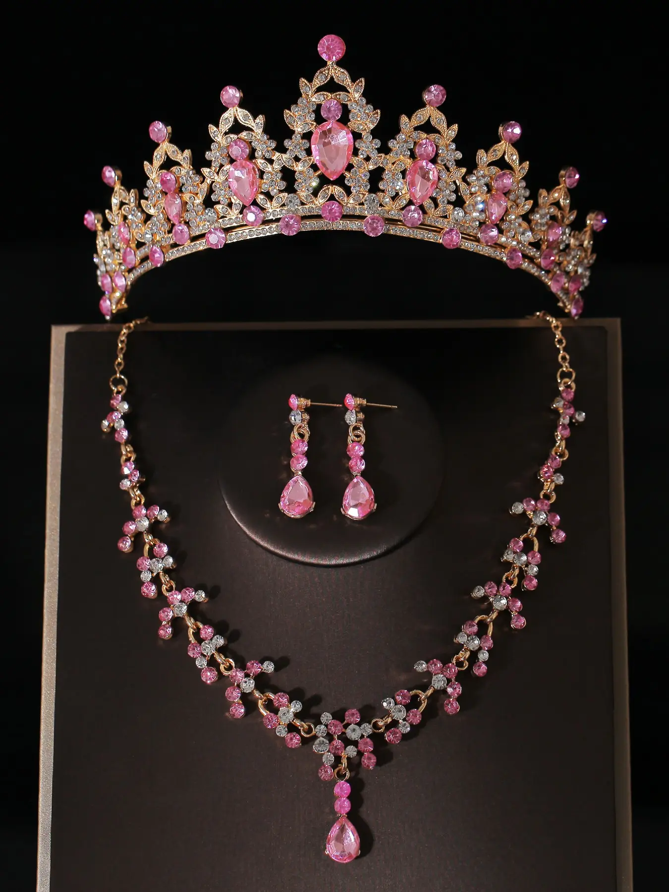 A set of bridal accessories for women, featuring a pink diamond-adorned crown, necklace, and earrings, wedding jewelry set suitable for bridal gowns and also perfect for wedding parties and celebrations.