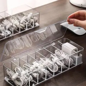 A cable storage box with a lid, designed to hold data cables, chargers and accessories, to achieve a tidy desk arrangement and to store cables.