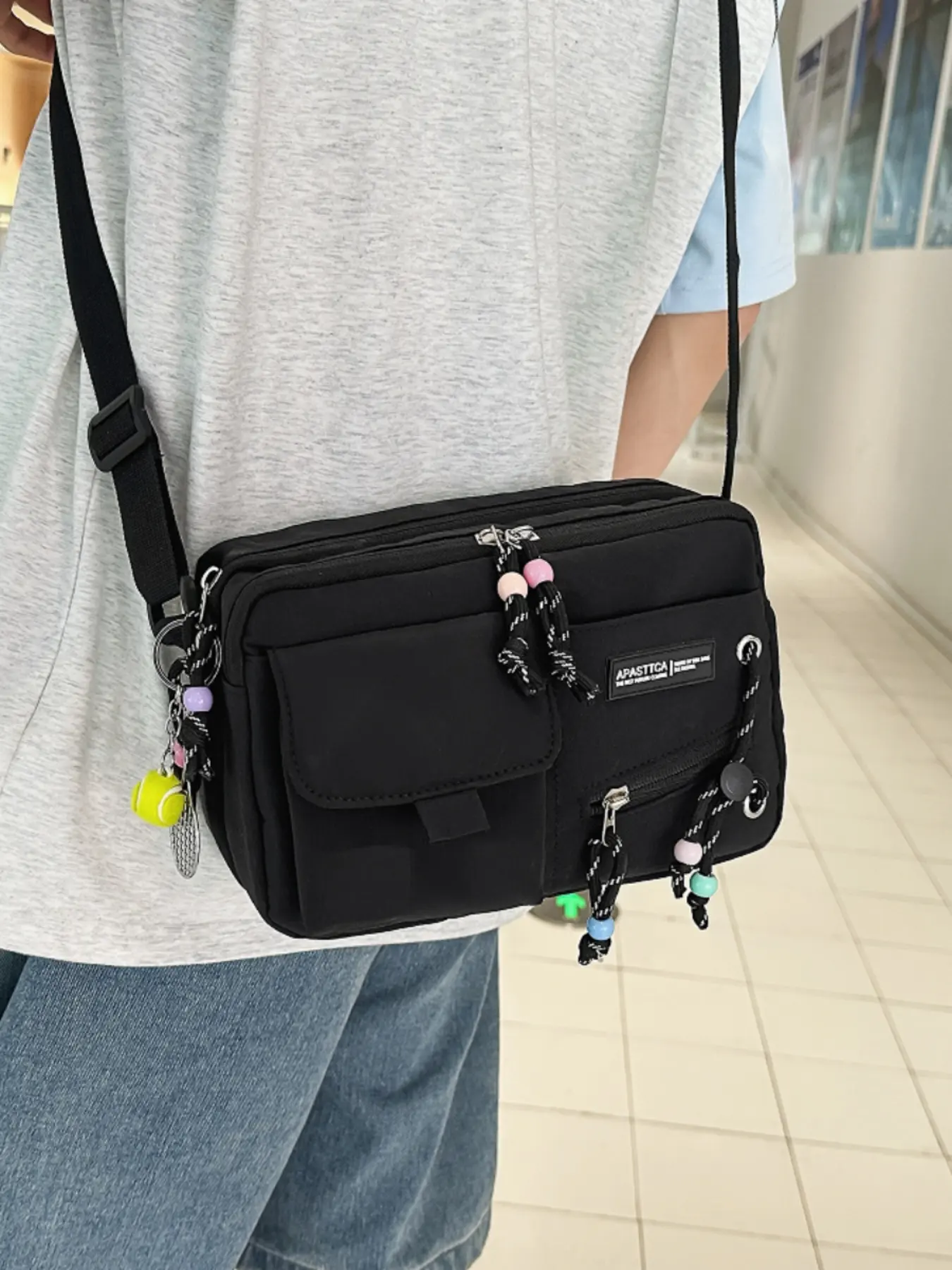 Simple multi-pocket lightweight adjustable crossbody bag, paired with cute beaded zipper pulls and tennis ball charms, unisex shoulder bag for daily outings, campus, and shopping.