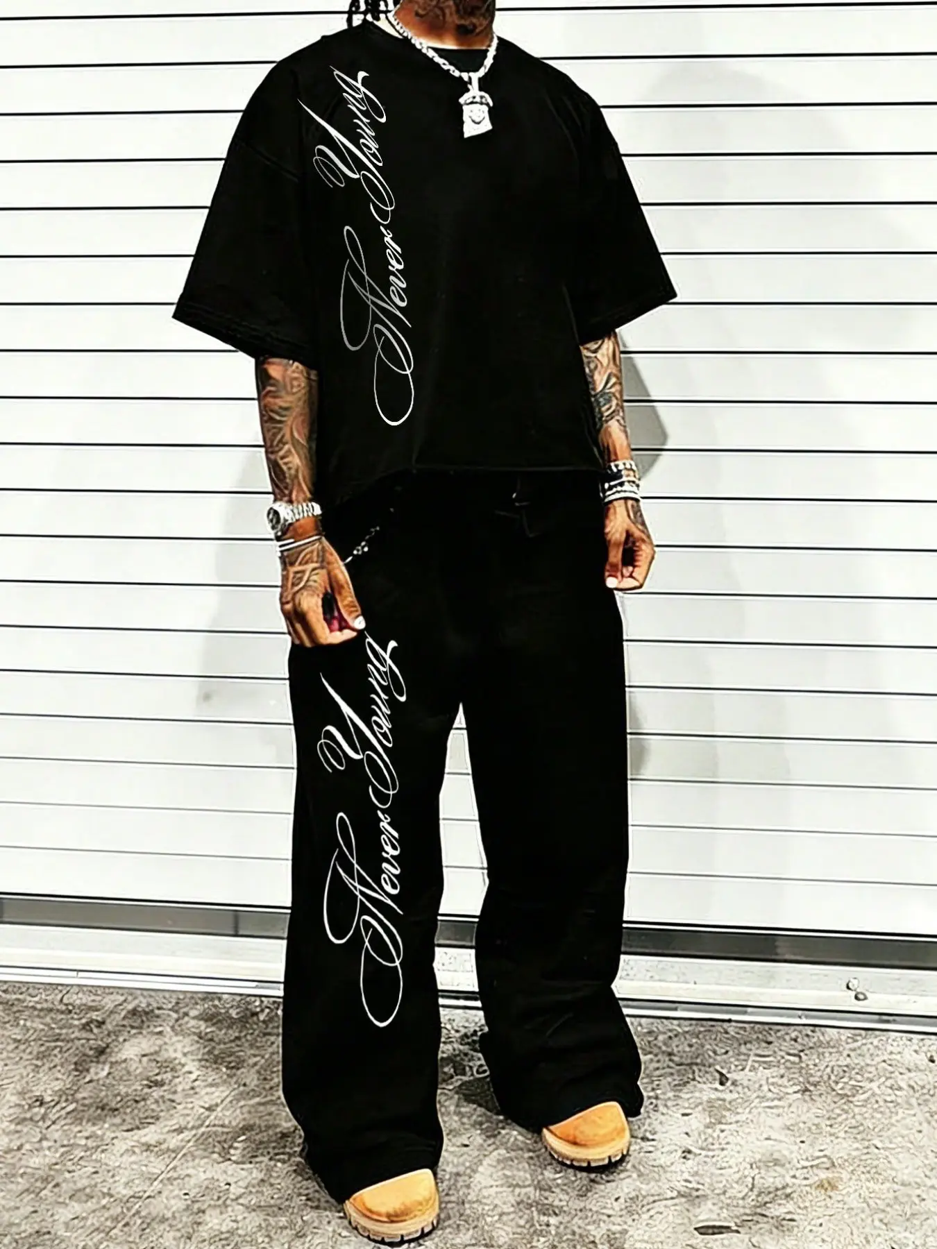 Vintage Chicano Style 2-Piece Menswear Outfit - Oversized Short Sleeve Tee & Wide Leg Pants with Vertical "Never Young" Script Graphic Print, Black Monochrome Streetwear Set for Hip Hop Parties & Daily Casual Wear