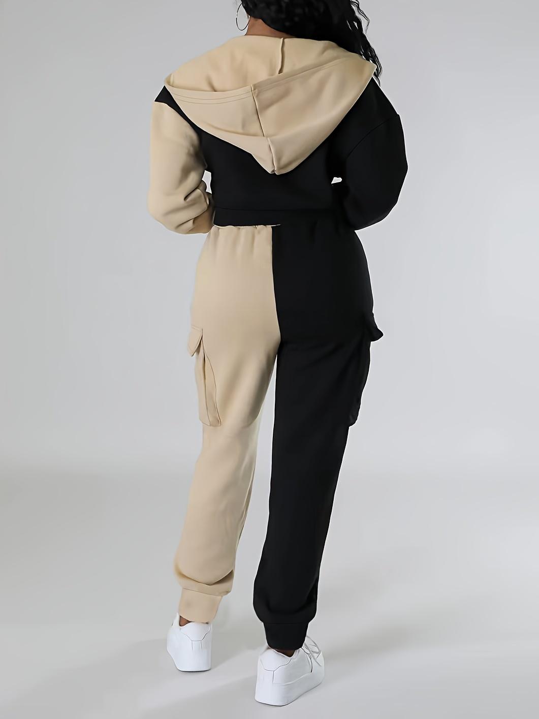 Sporty women's outfit: fashionable two-piece set with a short hooded jacket in contrasting colors and cargo sweatpants