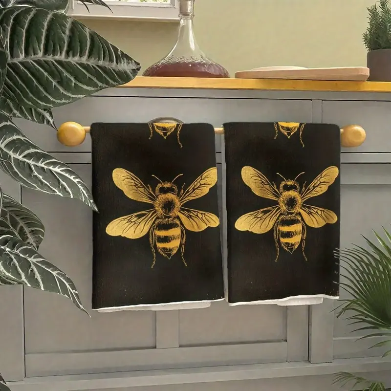 Two-pack of black towels, decorated with a double bee pattern and gold foil, lightweight, absorbent, soft, quick-drying, and machine washable. Suitable for kitchens, bathrooms, and gyms. A set of versatile decorative towels.