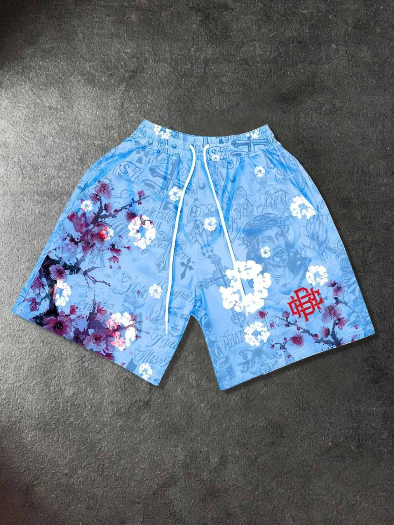 Unisex "Jesus" print Floral Baggy shorts—a trending style available in multiple colors. Featuring a cross print, these summer shorts include a men's all-over print beach style; a new arrival from a trendy Western-style streetwear brand. Graphic Shorts
