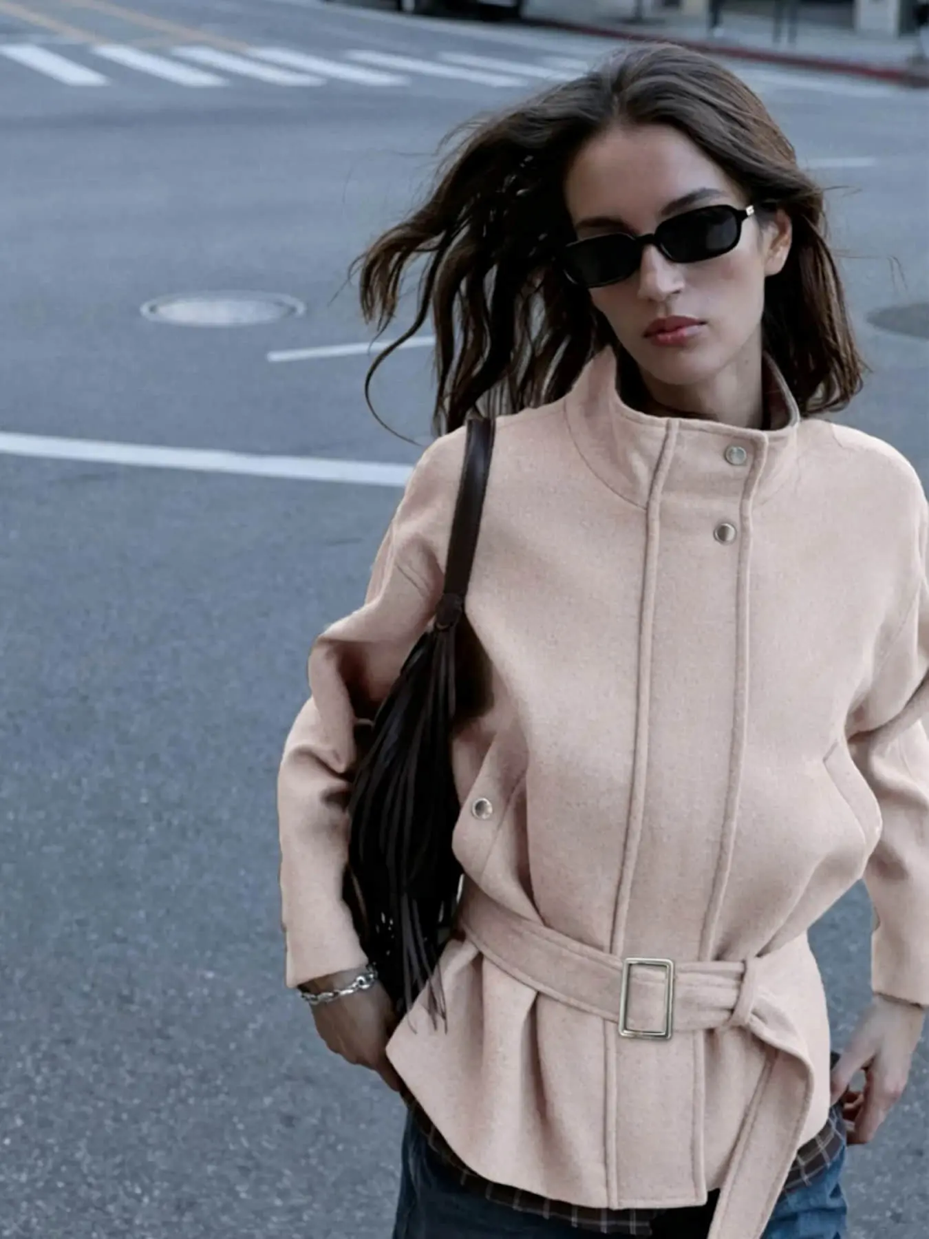 A women's fashionable, intellectual, and relaxed casual French style stand up collar and waist cinching jacket with a metal buckle waistband design, suitable for autumn and winter, street photography, shopping, and weekend outings.