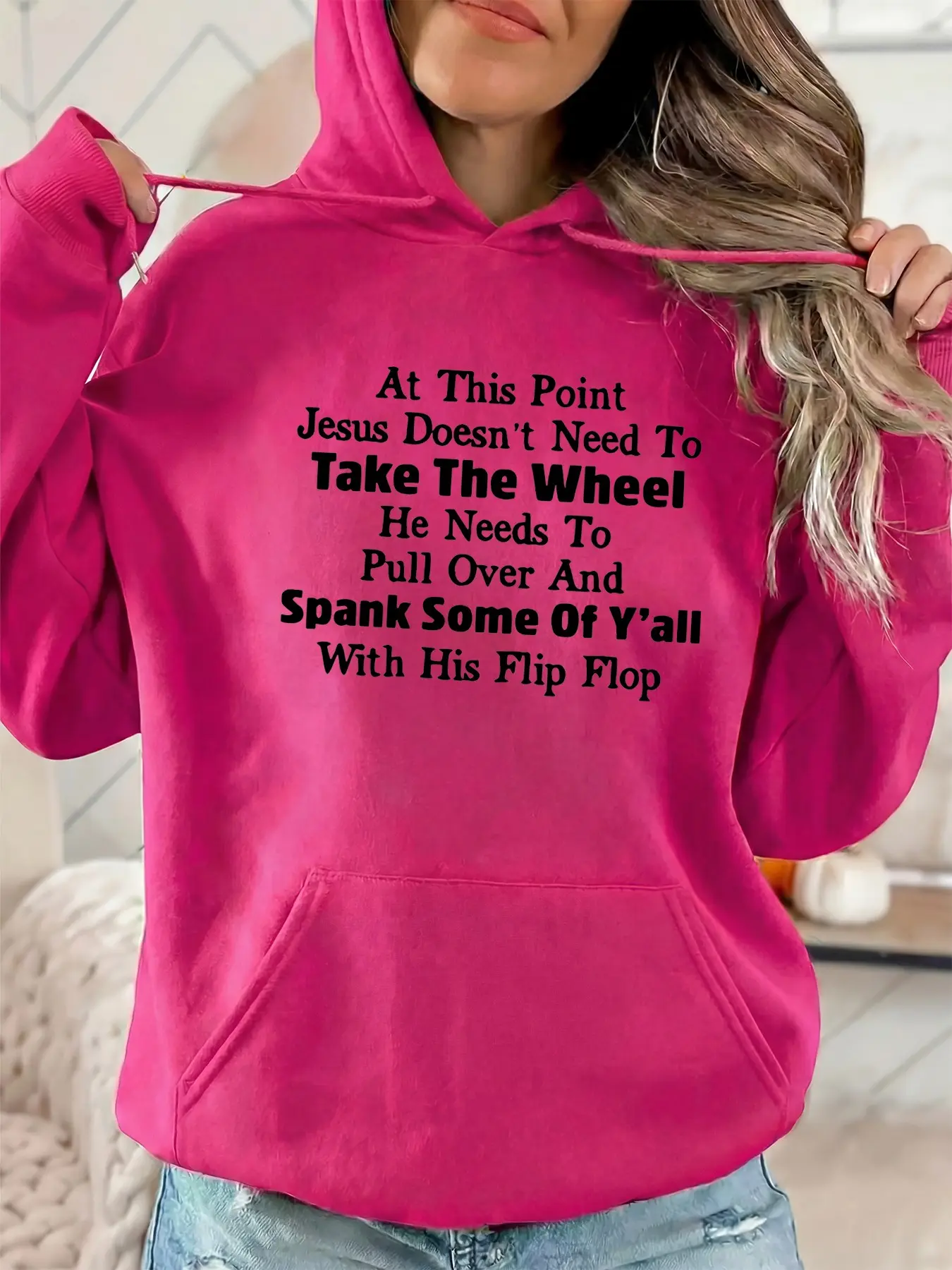 The stylish hooded sweatshirt for ladies features the print "AT THIS POINT JESUS DOESN'T NEED TO TAKE THE WHEEL" on it. It has drawstring kangaroo pockets and is a fall-winter casual sportswear sweatshirt. It is suitable for casual parties and sports wear