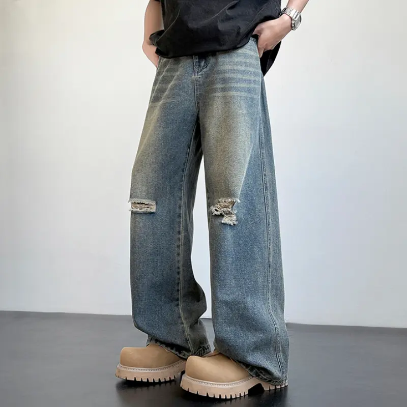 Vintage washed wide-leg denim jeans with intentional frayed knee rips, natural faded tonal shading and distinct side stitching; relaxed full-length silhouette matches chunky work boots for authentic retro street styling # sohochic