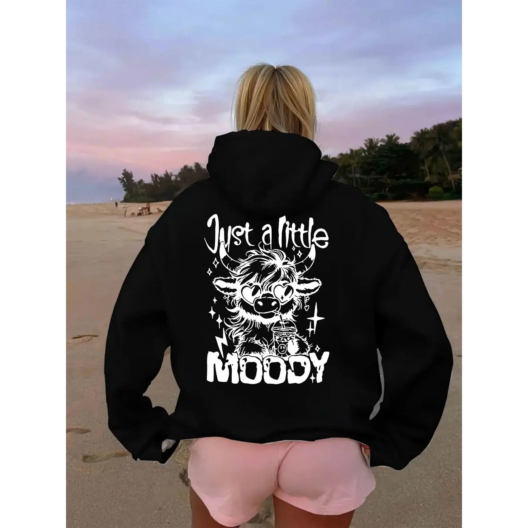 Printed with a cartoon cow wearing heart-shaped, the top reads "Just a little," and the bottom reads "MOODY."Women's casual fashion hooded fleece sweatshirt