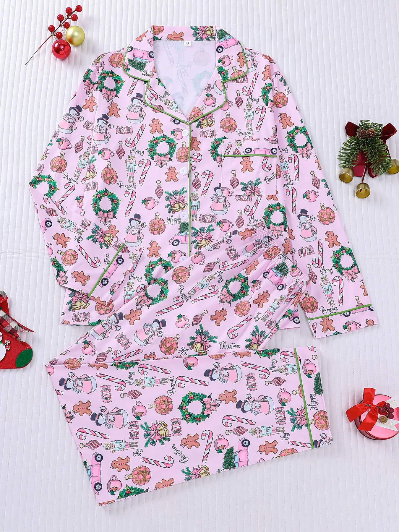 Women's 2‑piece Christmas pajama set, lapel long‑sleeve top & pants with gingerbread man, nutcracker, wreath & candy cane print. Pink set with green piping, button‑front, chest pocket, elastic‑waist. Soft sweet retro festive loungewear for ladies