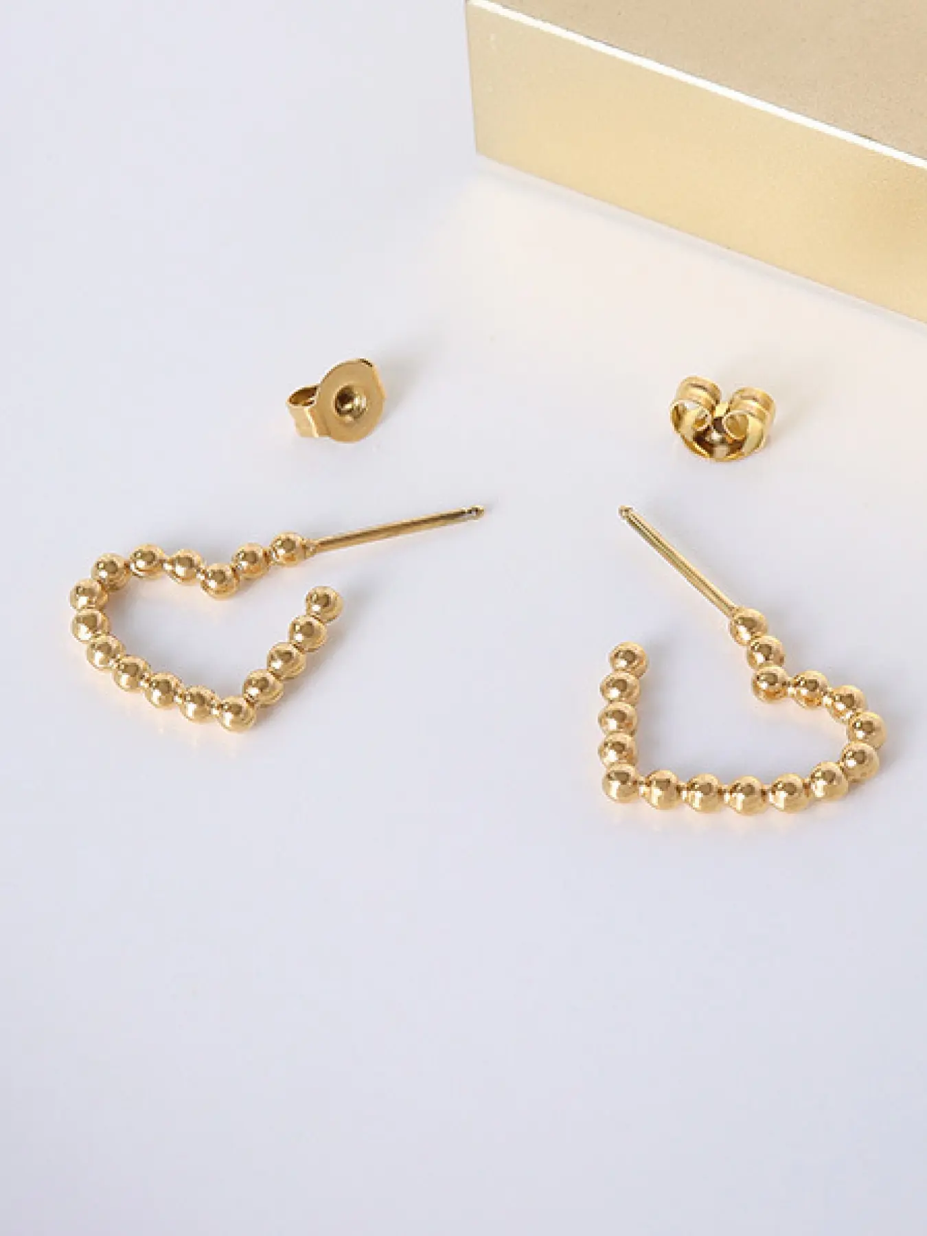 A pair of minimalist heart-shaped lacy earrings with smooth, delicate round beads, exuding a touch of playful charm. Perfect for daily commutes, dates, casual business settings, and more.