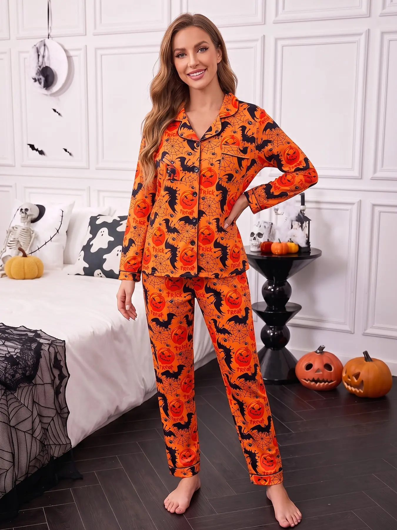 Women's 2-piece pajama set, orange base with Halloween prints of jack-o'-lanterns, bats, spider webs and Trick text, fun Halloween style. Black piping lapel top with pocket, soft elastic long pants, comfy all-season casual women loungewear Nightwear