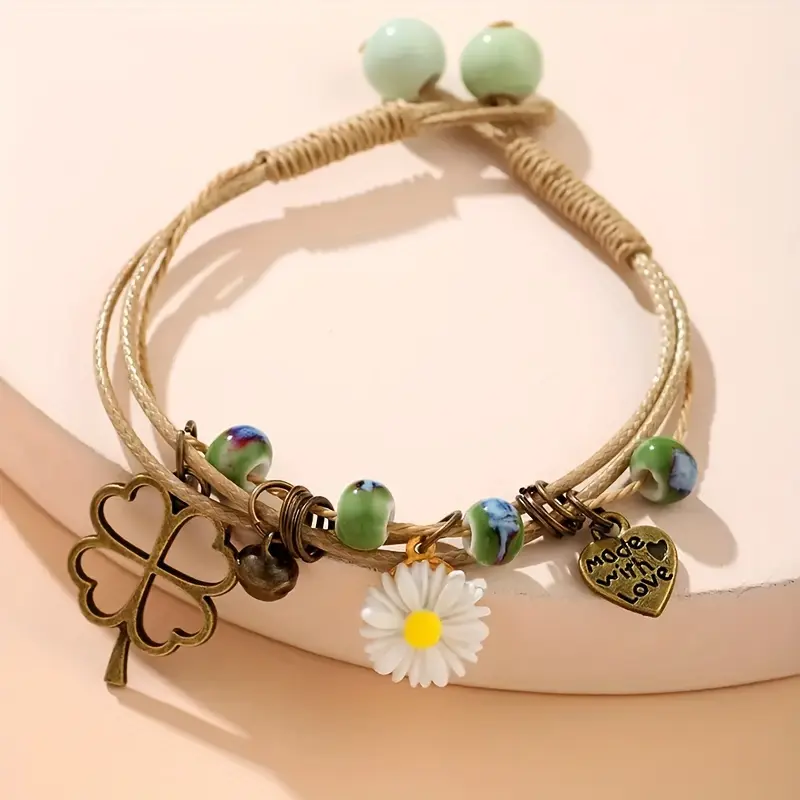 (Ceramic beads come in random colors and patterns) 1 piece of women's vintage bohemian adjustable woven bracelet with daisy, heart, clover, and bell pendants made with love.Gift for women, gift for family