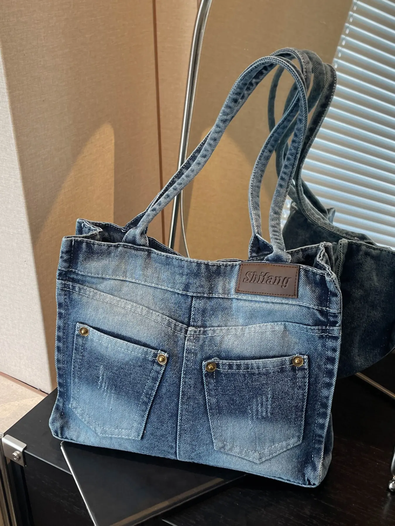 Niche vintage distressed denim tote bag with a jeans pocket design, washed gradient denim fabric, widened shoulder straps, and a large capacity—perfect for students, commuting, shopping, and casual outings. ...
