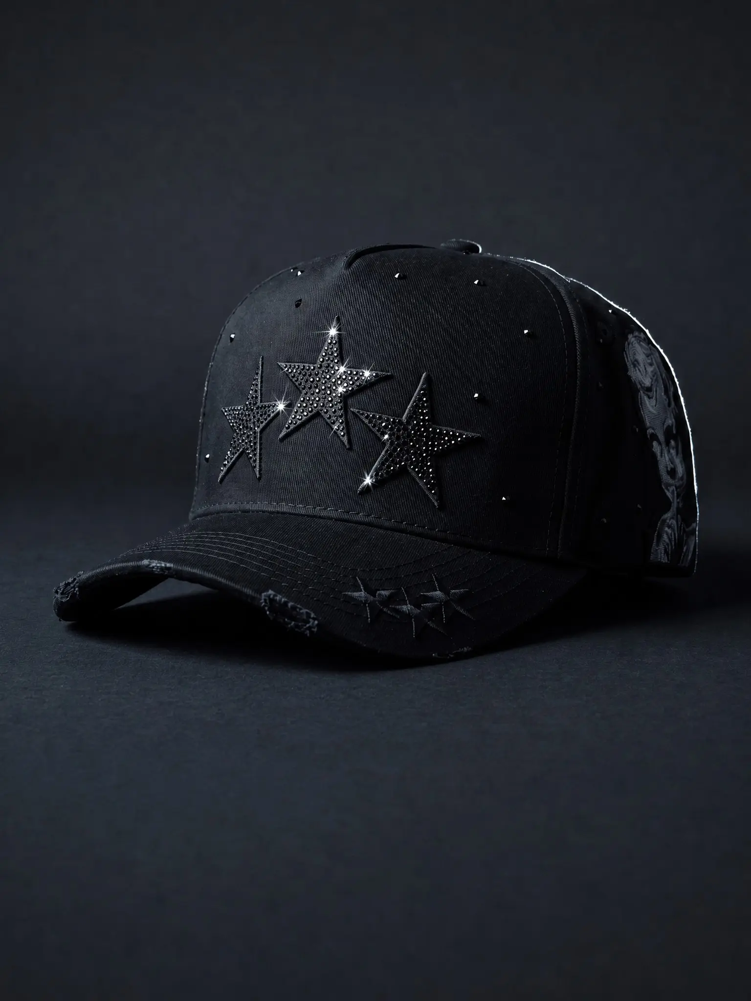 Black cap with three black rhinestone stars. Shushing child graphic and skull rose embroidery on the side. Distressed frayed brim. Caps with designs