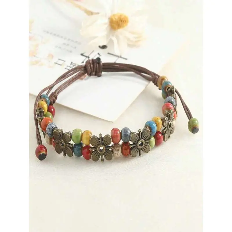 A vintage bohemian style hand-woven colorful beaded leather bracelet, featuring a flower pendant and adjustable clasp, suitable for women and girls to wear daily or as a party gift