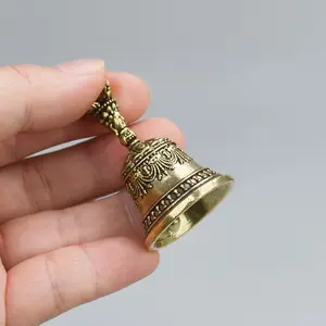 A carved hand-held bell-shaped Christmas bell ornament with a handle. The bell ornament produces a clear ringing sound. It is a festive decorative metal bell ornament suitable for soothing the mood. It is a carved antique-style bell handicraft.