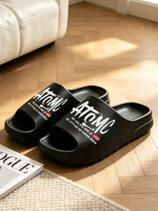 One-piece injection-molded slippers made of foamed EVA, featuring three-dimensional elevated thick soles and high resilience. Trendy single-strap slides with letter prints suitable for home wear and street outings (Runs small; order one size up)